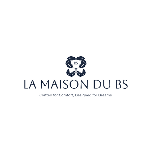 โลโก้ La Maison du BS ออกแบบด้วยลวดลายใบไม้โค้งมนสี่กลีบล้อมรอบอักษร BS สื่อถึงความสงบ สมดุล และธรรมชาติ โทนสีกรมท่าดูหรูหรา สื่อถึงแบรนด์ที่มุ่งเน้นความสบาย การพักผ่อน และความพิถีพิถันในทุกองค์ประกอบ พร้อมสโลแกน “Crafted for Comfort, Designed for Dreams